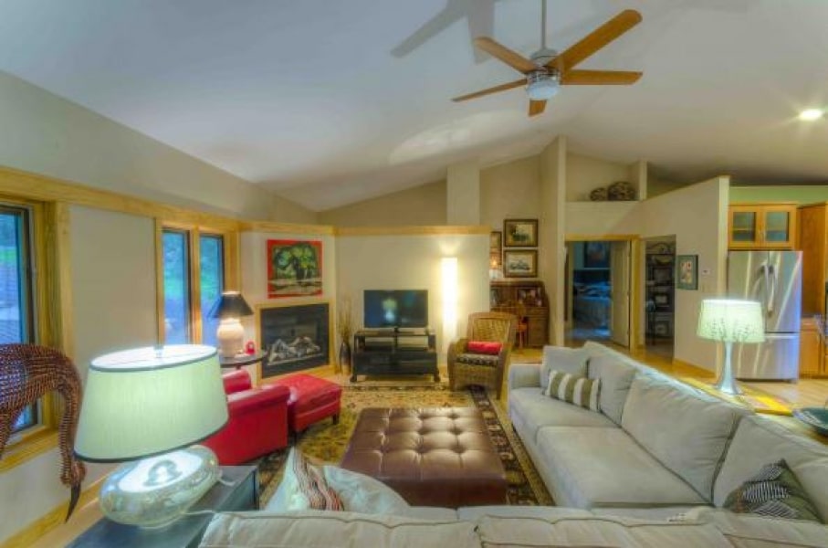 great room vaulted ceiling with exposed beams and partial wall