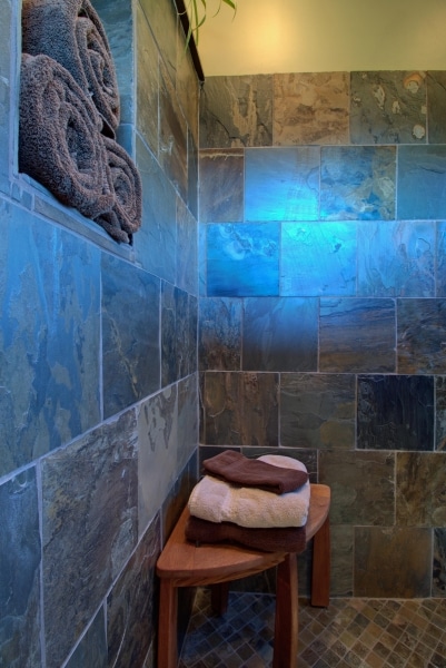 teak seat in walk-in shower, tiled with natural slate
