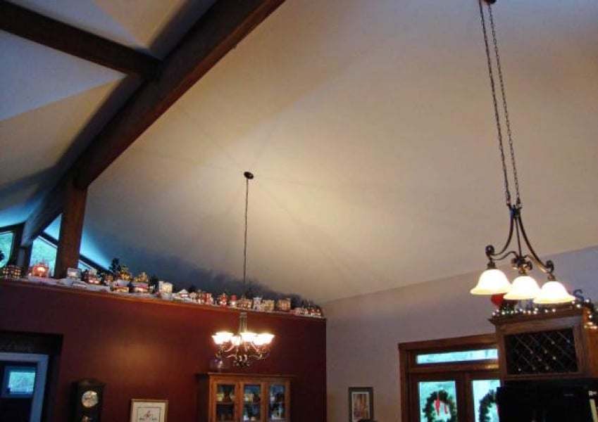 great room vaulted ceiling with exposed beams and partial wall