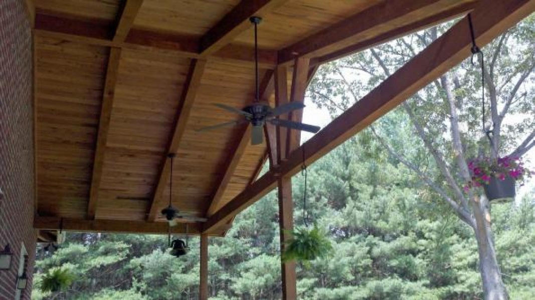 looking up under wood porch roof with exposed beams or other wood parts