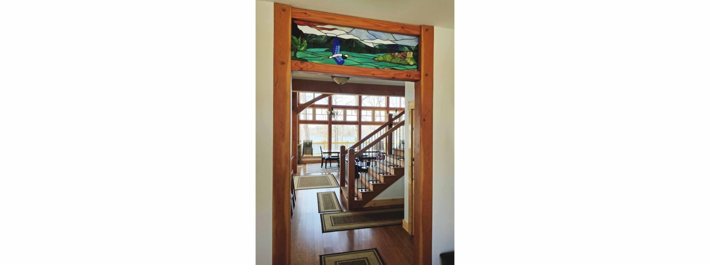 image of blue heron over Smith Mountain Lake featured as a transom at foyer of Heron Point; stained glass artwork by SER Art in Moneta; builder Timber Ridge Craftsmen Inc